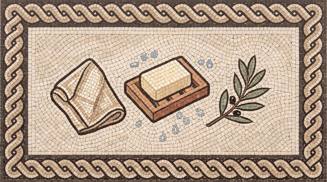 Mosaic illustration of a bar of soap on a slatted wooden soap dish beside a linen cloth and olive leaves.